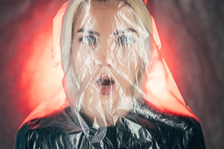 Shocked woman. Art defocused portrait. Plastic pollution. Save planet. Waste reuse. Scared woman in...