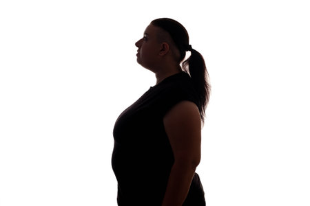 Obesity problem. Liposuction treatment. Fat burn. Plus size model. Profile portrait of unhappy chubby overweight woman silhouette isolated on white copy space background.の写真素材