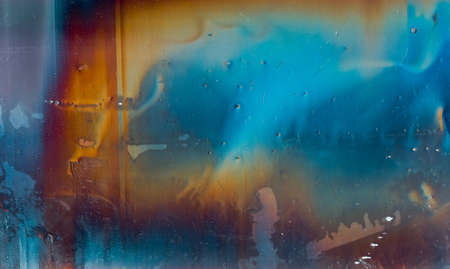 Colorful abstract background. Distressed texture. Wet distorted stained display with rainbow color gradient orange blue glitch defect dust scratches grain noise.の写真素材