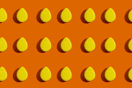 Easter banner. Seamless pattern. Festive bakery art. Abstract background. Sweet gingerbread eggs with yellow icing spots decoration isolated on orange.の写真素材