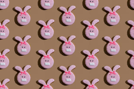 Bunny gingerbread cookies pink icing medicine mask ornament isolated on beige.