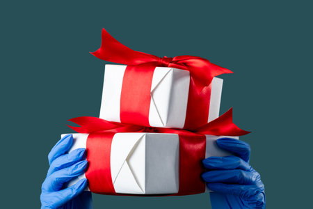 Father day celebration. Gift surprise. Pandemic protection. Hands in medicine gloves holding present...