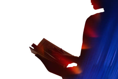 Double exposure silhouette. Knowledge wisdom. Blur red lens flare blue neon light rays flecks in dark contrast outline of inspired woman reading book isolated on white copy space background.の写真素材