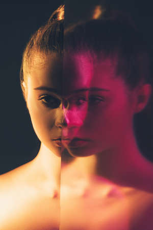 Female duality. Mental disorder. Subconscious crisis. Double exposure silhouette night half face portrait of pensive woman with defocused mirror reflection in pink neon light isolated on black.の写真素材