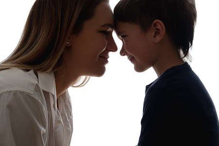 Family care. Parents support. Empathy love. Close relationship. Friendship encouragement. Happy mother with son touching foreheads looking each other isolated on white side view.の写真素材