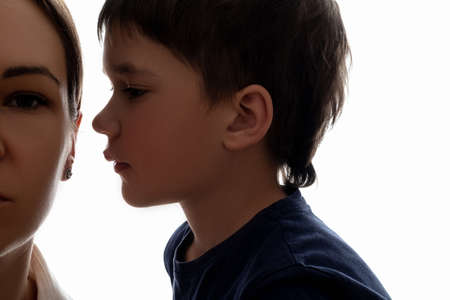 Family secret. Parents frustration. Silence privacy. Trust confidence. Little boy staying close to mother ear going say important confession isolated on white.の写真素材
