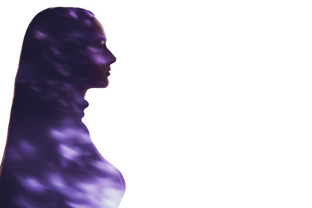 Double exposure silhouette. Spiritual energy. Enlightenment aura. Blur neon purple light fleck in profile outline of peaceful woman isolated on white copy space background.の写真素材