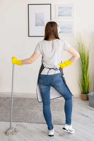 Home chores. Janitor woman. Cleaning day. Enjoying result. Satisfied lady in protective gloves apron...