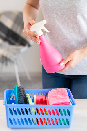Home chores. Cleaning tools. Housewife work. Unrecognizable woman taking cleaner spray from basket...