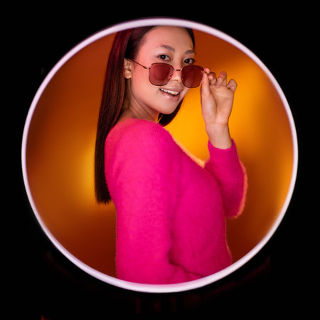 Eyewear fashion. Beauty portrait. Modern accessories. Smiling glamour Asian girl in pink in...