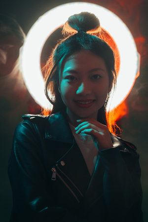Color night portrait. Cyberpunk people. Futuristic fashion. Blue neon light smiling Asian girl in...