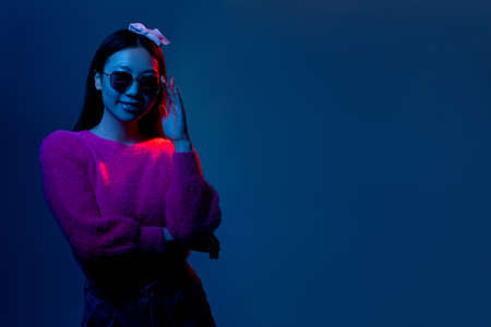 Neon fashion. Night beauty portrait. Futuristic nightlife. Glamour smiling Chinese girl in pink in...