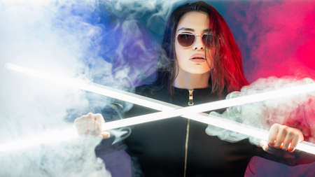 Neon smoke portrait. Cyber punk. Rave party. Glamour woman in sunglasses in pink blue neon light...