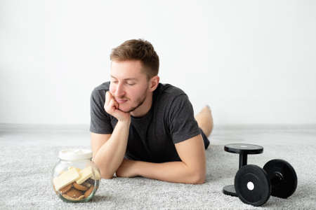 Weight loss problem. Puzzled man. Fitness program. Diet concept. Thoughtful guy in sportswear...