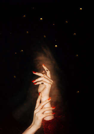 Festive background. Female elegance. Holiday party. Unrecognizable woman hands holding together long...