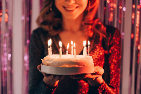 Birthday greeting. Happy woman. Festive bakery. Unrecognizable smiling lady feeling amazed holding...