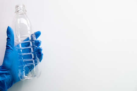Zero waste. Marine pollution. Ecology problem. Volunteer hand in surgical gloves holding clean empty...