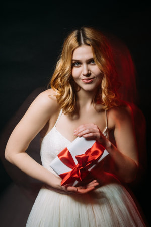 Wedding party. Happy woman. Holiday present. Festive greeting. Pretty smiling woman holding gift box...