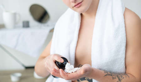 Shaving foam. Skincare product. Facial treatment. Morning hygiene. Unrecognizable shirtless man with...
