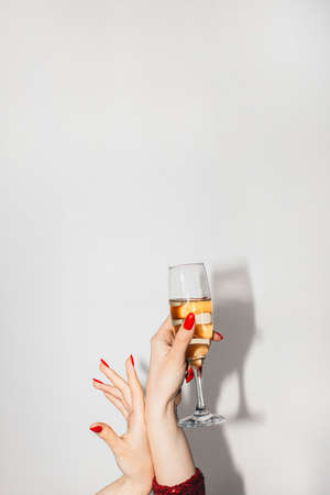 Party toast. Christmas celebration. Holiday drink. Advertising background. Elegant female hands holding champagne flute pointing up copy space isolated white.の写真素材