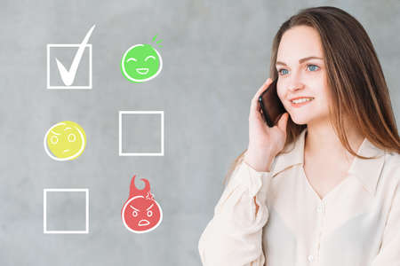 Customer feedback. Mobile survey. Service quality report. Happy smiling female consumer rating best impression on phone with emoticon checklist illustration.の写真素材
