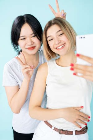 Funny selfie. Happy women. Enjoy life. Ethnic friendship. Pretty smiling asian caucasian ladies...