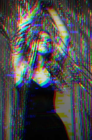 Christmas party. Happy woman. Festive celebration. Stylish sensual lady elegant dress dancing under shimmering cascade curtain black white photo colorful glitch effect defocused.の写真素材