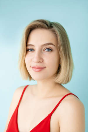 Natural beauty. Pretty woman. Casual style. Model shooting. Beautiful smiling lady nude makeup looking at camera isolated blue.の写真素材