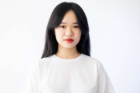 Beautiful asian woman. Perfect skin. Fresh look. Natural care. Pretty dark haired lady red lipstick isolated white.の写真素材