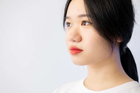 Asian skin care. Beautiful woman. Smooth treatment. Advertising background. Pretty dark haired lady red lips isolated white copy space.の写真素材