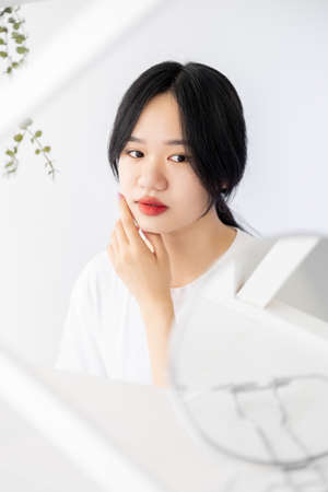 Beautiful asian woman. Morning facial treatment. Skincare procedure. Pretty lady posing with mirror...