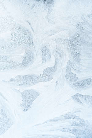 Frosty pattern. Ice background. Cold weather. Christmas holiday. Abstract white snowflake crystals...