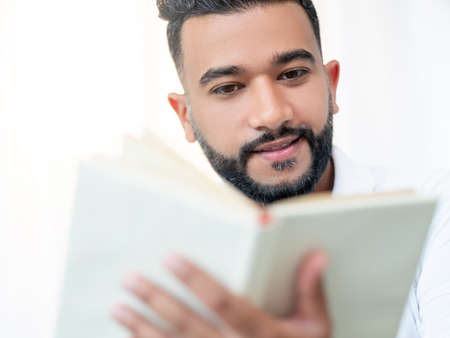 Home relax. Inspired man. Book lover. Happy arabian guy enjoying reading isolated white background.