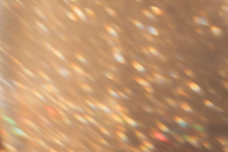 Blur light background. Bokeh sparks. Disco rays reflection. Party gleam. Defocused colorful orange...