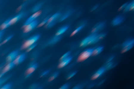 Bokeh light. Lens flare overlay. Flash leak. Blur optical rays. Defocused blue pink flecks glow on dark night abstract background.の写真素材