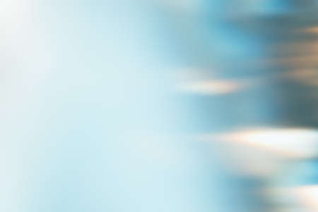 Light flare filter. Blur glow overlay. Sunlight reflection. Bokeh radiance. Defocused blue white orange color gradient texture abstract background.の写真素材