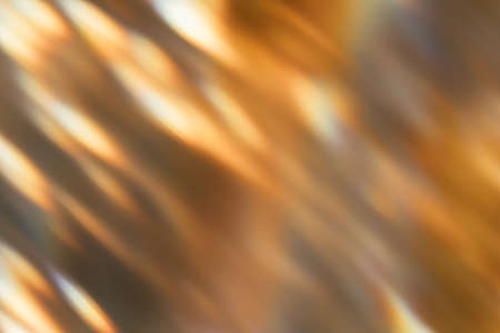 Blur glow overlay. Bokeh rays. Sunlight beam glare. Gleam leak. Defocused golden orange black light flecks on dark abstract background.の写真素材