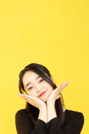 Cute girl. Skin care. Facial treatment. Beauty freshness. Advertising background. Attractive young woman with perfect healthy clean face on yellow copy space.の写真素材