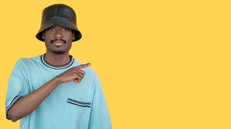 Pointing gesture. Rapper man. Information banner. Stylish hipster guy in leather hat showing finger...
