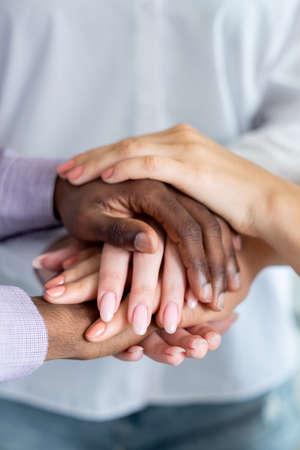 Friendly support. Good job. Unity collaboration. Unrecognizable man and woman putting hands together.の写真素材