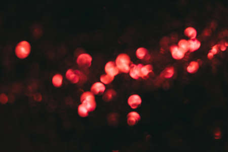 Bokeh light overlay. Defocused glow. Blur decorative illumination. Neon red color light shiny circles reflection on dark black abstract background.の写真素材