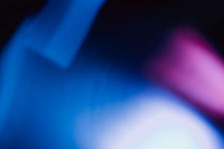 Lens flare overlay. Defocused glow. Bokeh ultraviolet light leak. Blur neon purple blue white color glare texture on dark abstract background.の写真素材