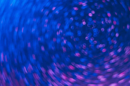 Bokeh light texture. Neon background. Glowing circles swirl. Festive illumination. Defocused...
