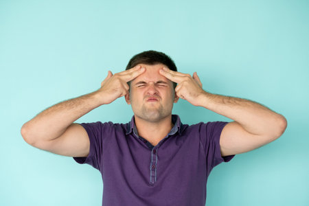 Shocked man. Ridiculous face. Playing fool. Clueless guy in violet t-shirt closing eyes holding...