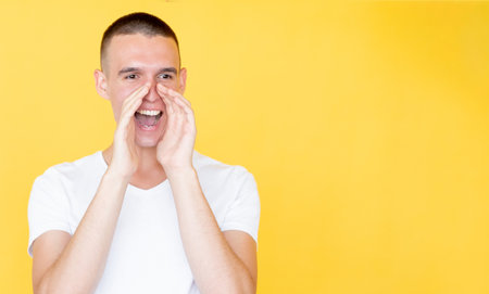 Megaphone gesture. Shouting man. Important information. Happy smiling guy holding hands on mouth...
