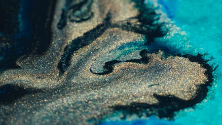 Ink background. Abstract colorful design. Creative paint mixture. Blue gold black colors blend