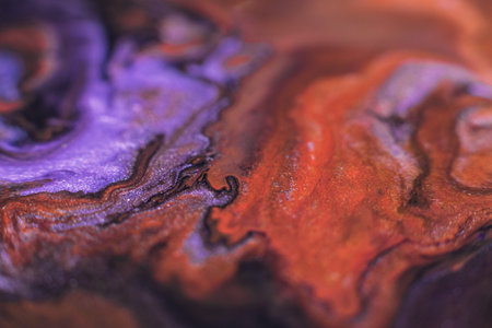 Liquid paint art. Macro ink background. Purple violet orange colors mixの写真素材