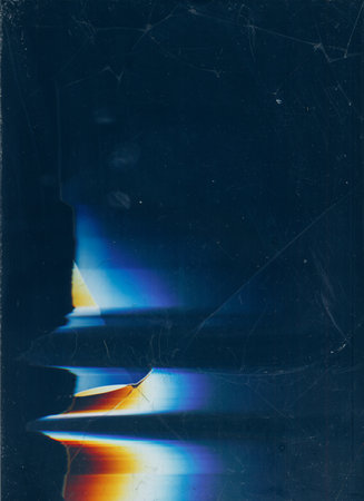 Aged filmstrip. Brown blur overlay. Dust flecks on dark background.