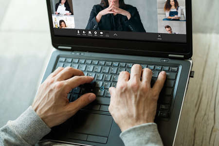 Business video call. Corporate telework. Remote communication. Male freelancer working online with team in virtual office on laptop screen.の写真素材