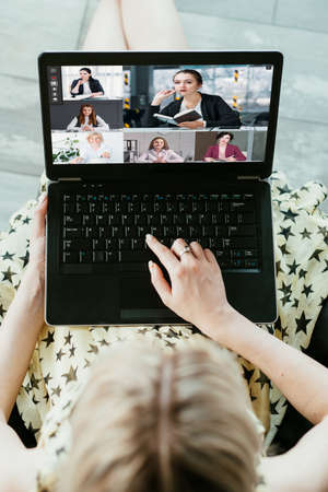 Business web chat. Group video conference. Internet communication. Woman hands using laptop working online with professional team on screen in digital office.の写真素材